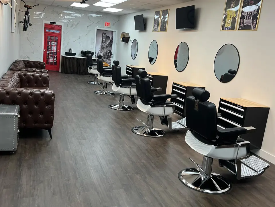 The row of barber chairs and mirrors, leather sofas on the left