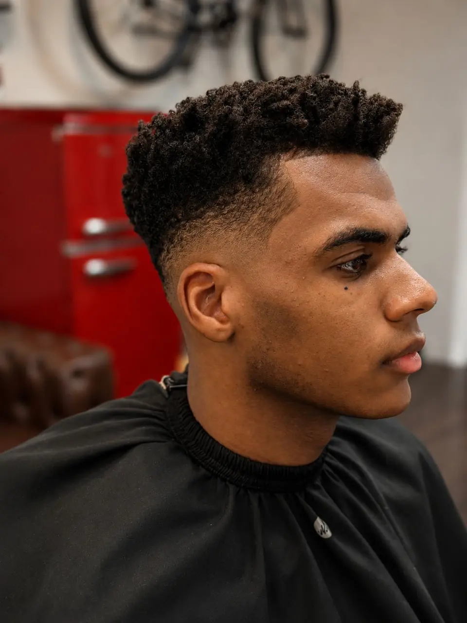 Tight curls on top over a skin fade