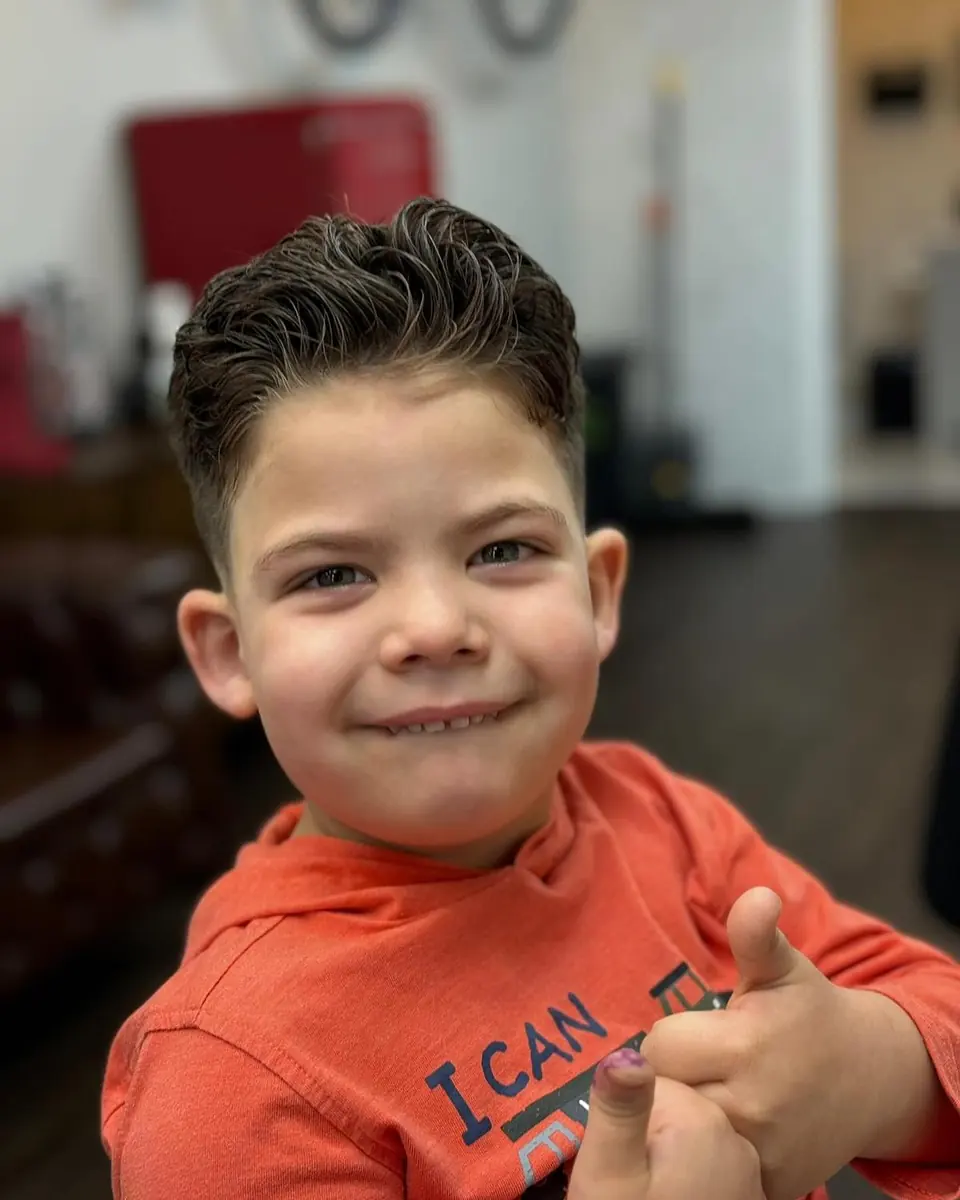 A boy smiling after his haircut