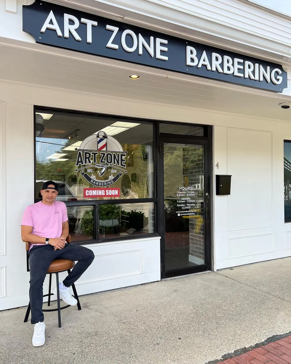 Luke Santos outside the shop before opening day, a Coming Soon sign on the door