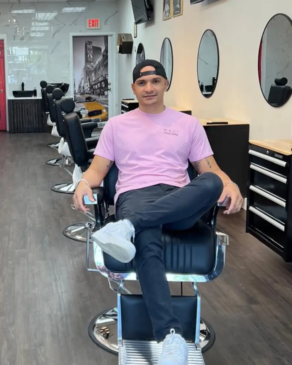 Luke, owner of Art Zone, sitting in a barber chair in the shop